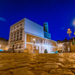 Rynek i ratusz w Kożuchowie. Zdjęcie zrobione wieczorem, z oświetleniem. Błękitne niebo.